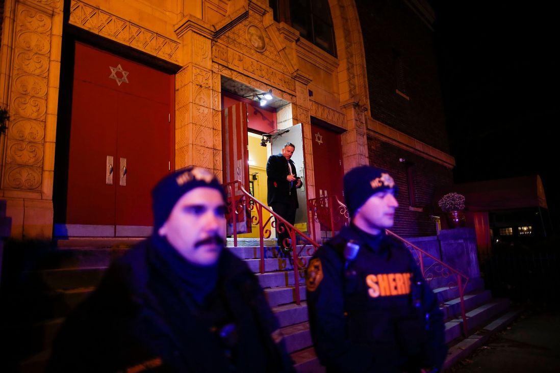 Officers stand outside of a vigil for the victims of a shooting in Jersey City, N.J.,